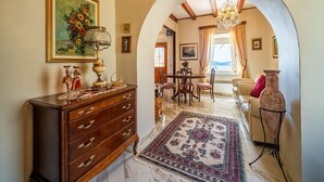 A spacious living area with a wooden dresser, a chandelier, and a dining table with chairs. - Villa Melita with Swimming Pool (Trsteno)