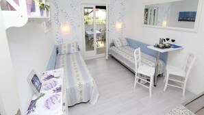 A cozy room with a bed, a small table with chairs, a mirror, and a window. - Apartments Frane - One Bedroom Apartment with Terrace (Rovinj)