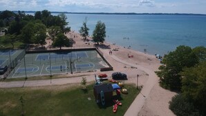 A lakeside property with a tennis court, beach, and boats. - Equestrian Charm near Torch Lake: Two homes in one! (Rapid City)