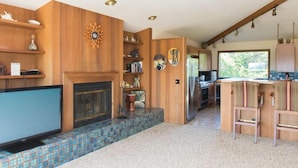Una cocina moderna con paredes de madera, salpicadero de azulejos y televisión empotrada.