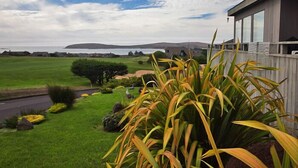 Una propiedad residencial con vista al mar, un césped cuidado y una valla de madera.
