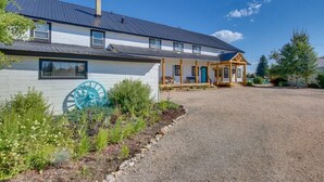 Ein zweistöckiges Haus mit Kopfsteinpflaster-Einfahrt und überdachter Veranda.