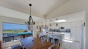 A spacious kitchen with a large island, modern appliances, and a view of the outdoors. - Dabbling Duck - Light, open, warm home on the 14th fairway, great views (Bodega Bay)