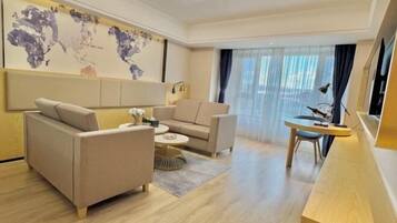 A modern living room with a sofa, armchairs, a coffee table, and a desk with a chair.