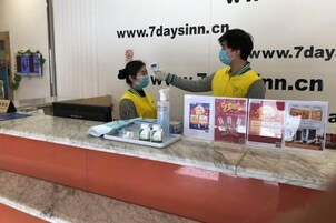 Una recepción con mostrador de mármol, una computadora y exhibición de material promocional.