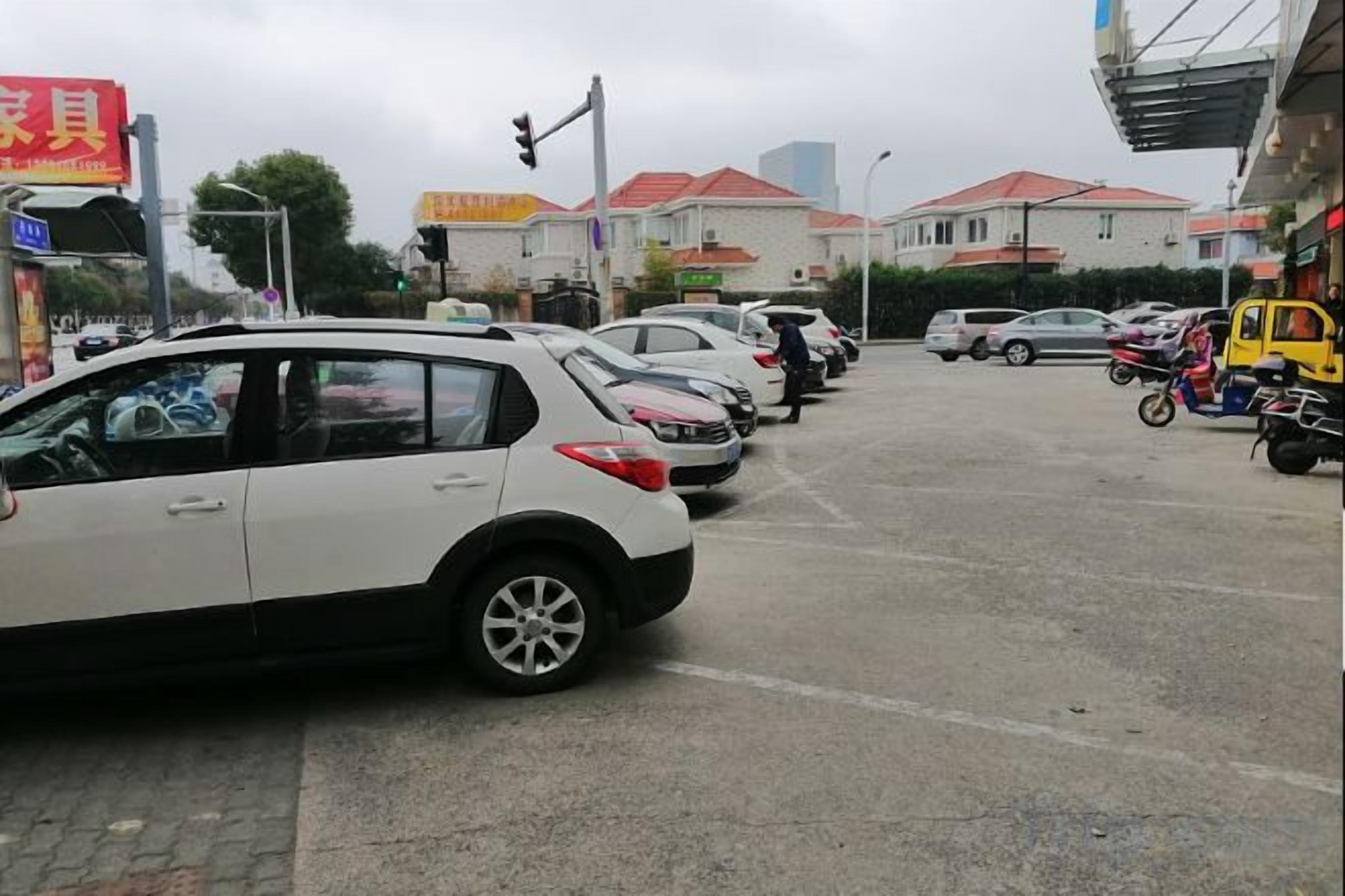 A parking lot with multiple cars and a yellow vehicle.