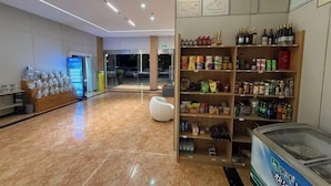 Eine moderne Hotelhalle mit Marmorboden, einer Sitzecke und einem Getränkeautomaten.