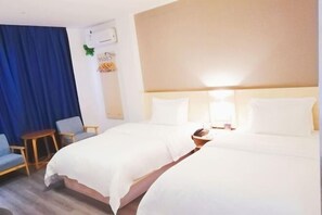 A hotel room with two beds, a small table, two chairs, a blue curtain, and a wall-mounted air conditioner. - Yixuan Hotel (Ningbo Xiangshan People's Square) (Xiangshan)