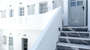 Un edifici blanc amb una escalinata de marbre que condueix a una porta.
