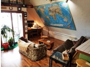 Relax in a cozy space with a world map, comfortable sofa, and potted plant.