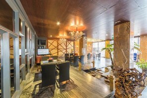 A spacious lobby with a modern chandelier, a reception desk, and a seating area with chairs and a table. - Jinhai'an Sunshine Holiday Hotel (Yongfu)