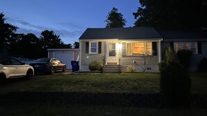 Une maison de plain-pied avec un garage, une allée et une pelouse.