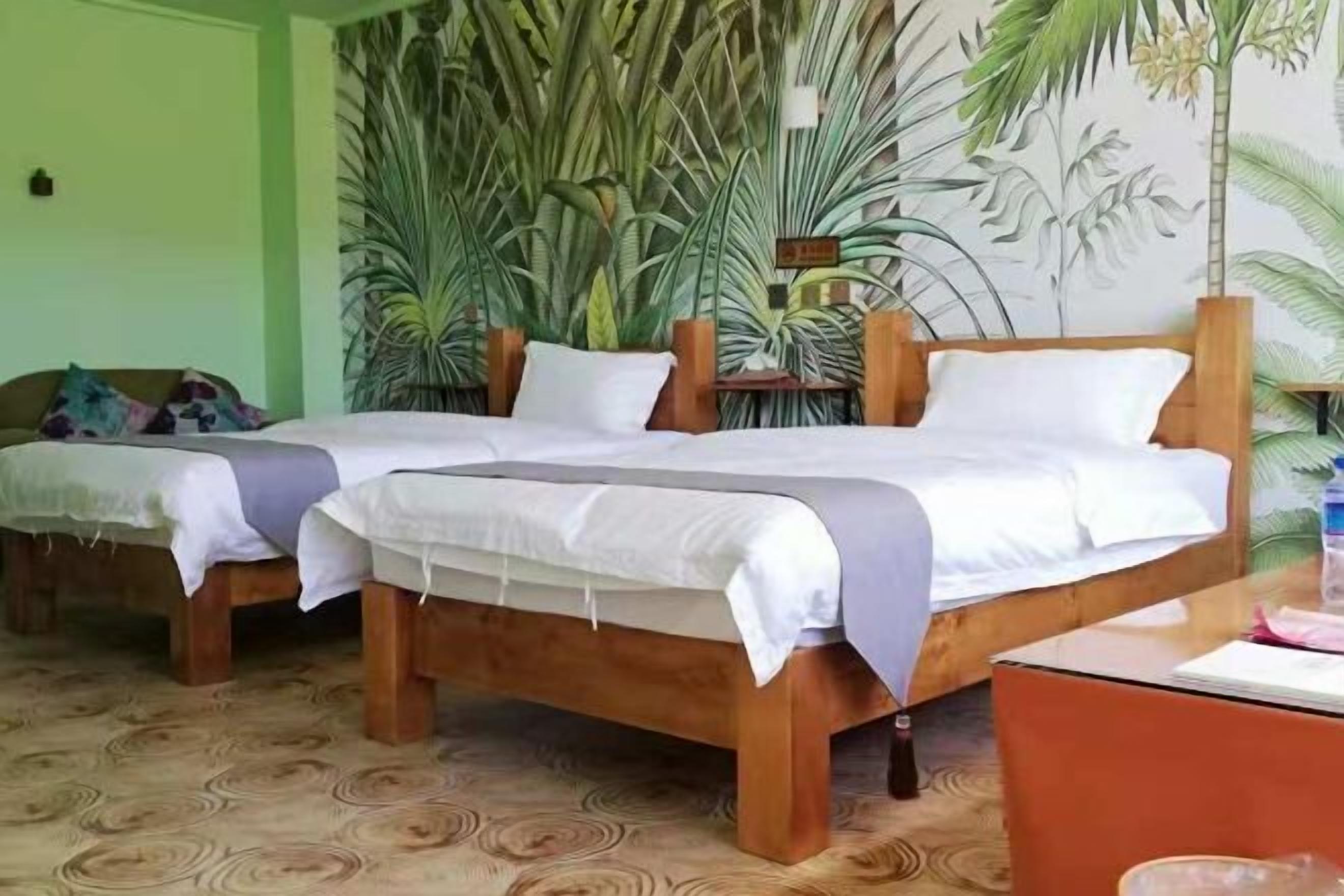 Una habitación con dos camas de madera, una pared verde y un mural de plantas.