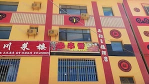 A building with multiple signs, including one for a restaurant and another for a hotel. - Nianlun Theme Hotel (Ninglang)