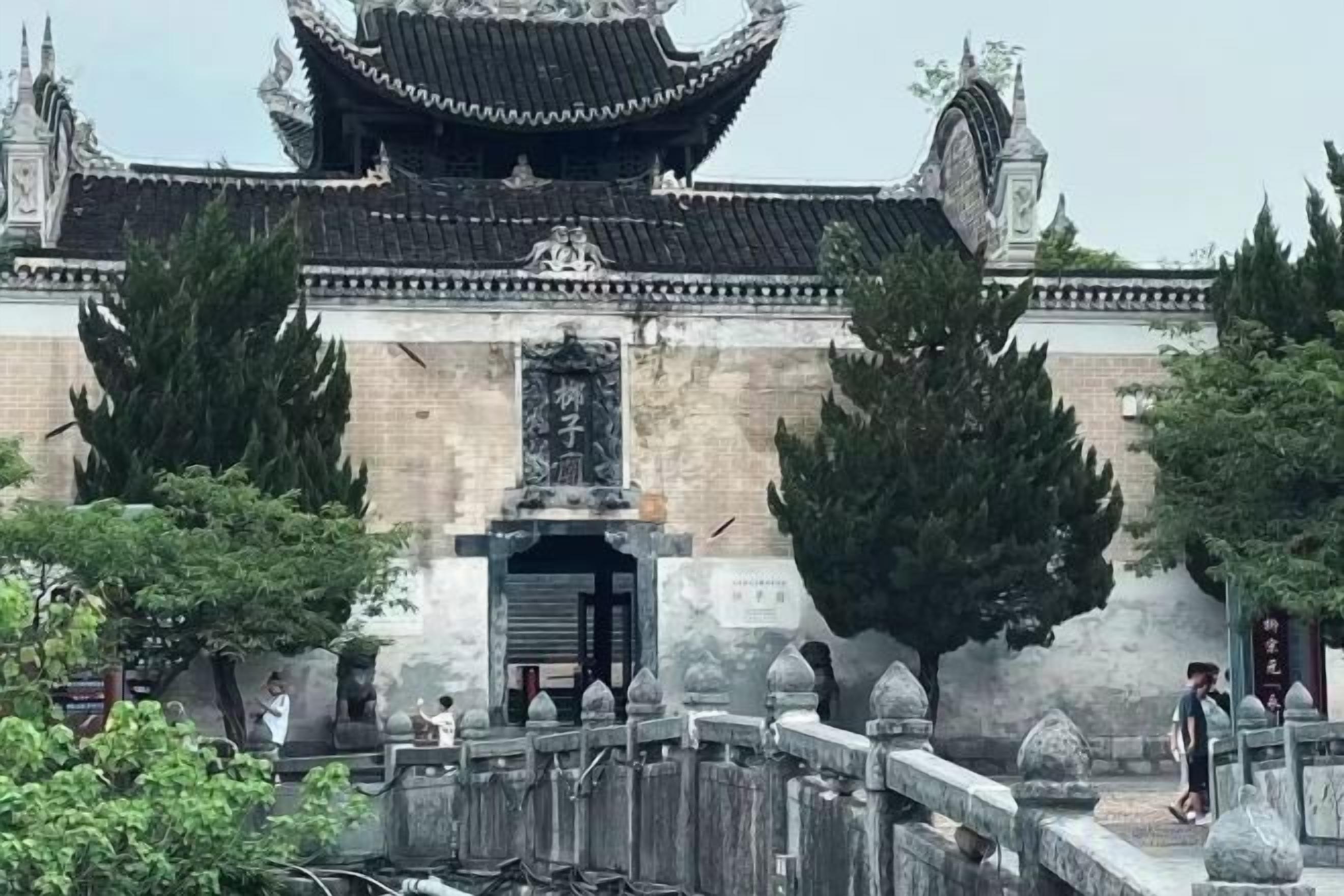 Um edifício tradicional com uma entrada imponente, telhado de telhas e parede de pedra.