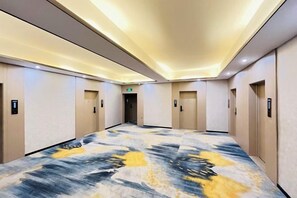 A hotel corridor with a carpeted floor, doors, and a ceiling light fixture. - Zhicheng Select Hotel (Yongzhou Vocational and Technical School) (Yongzhou)