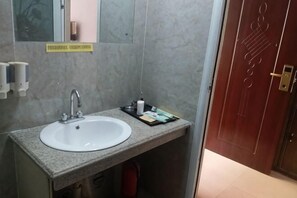A bathroom with a white sink, a mirror, and a towel rack. - Shujie Hotel (Ji'an)