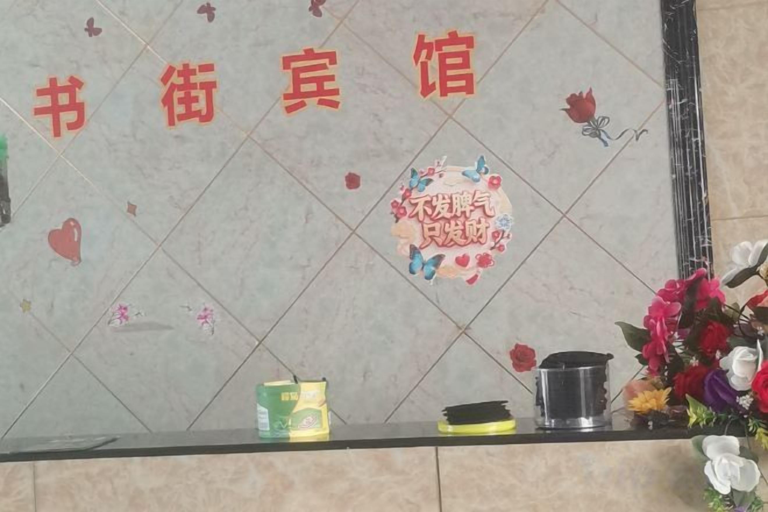 A tiled wall with a floral design and a plaque.