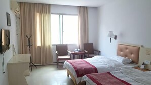 A hotel room with two beds, a desk, a chair, a coat rack, and a window with curtains. - Shujie Hotel (Ji'an)