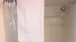 Eine Dusche mit Haltegriff, Handtuchhalter und Duschkopf.