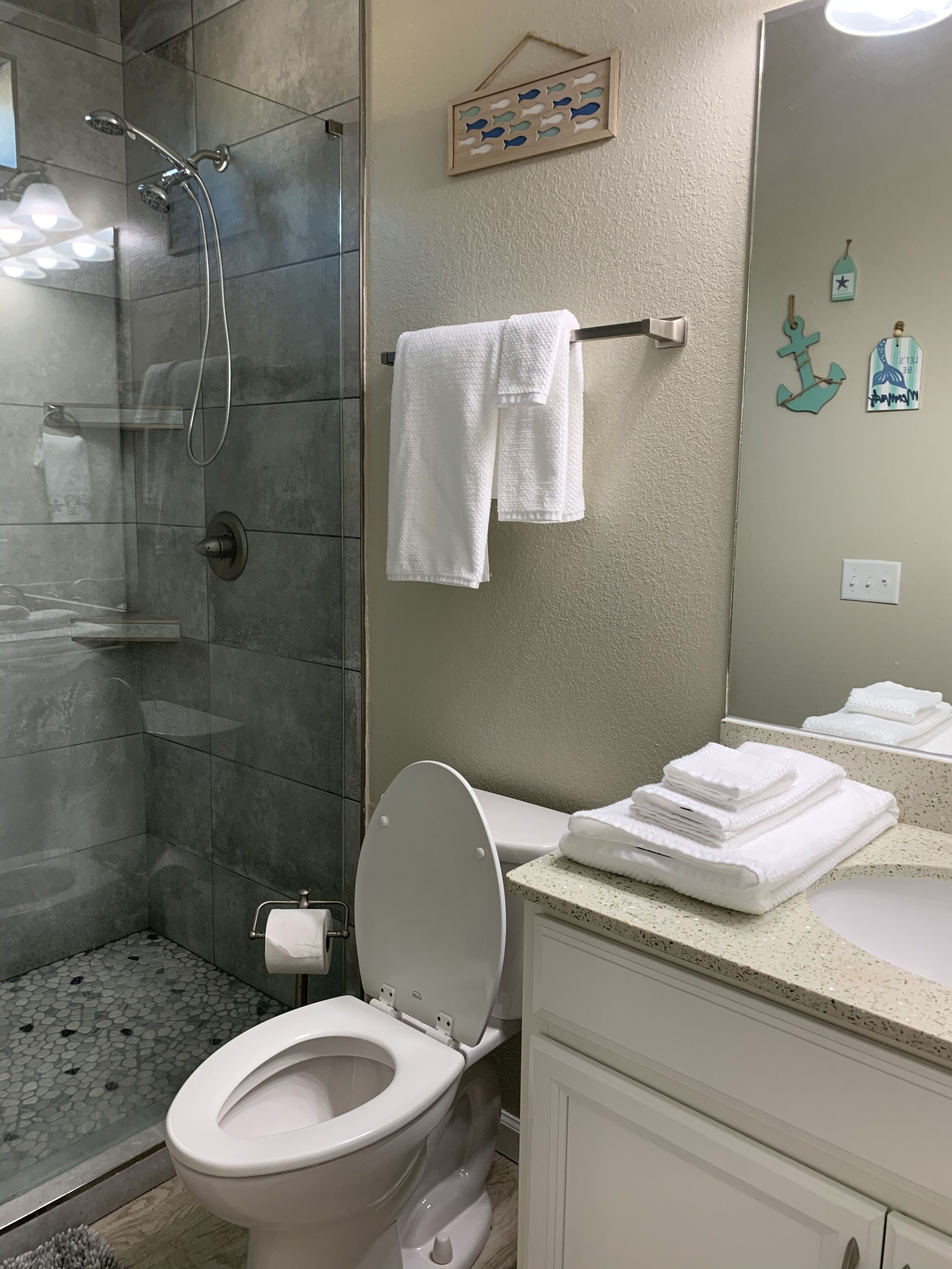 A bathroom with a shower, toilet, and sink.