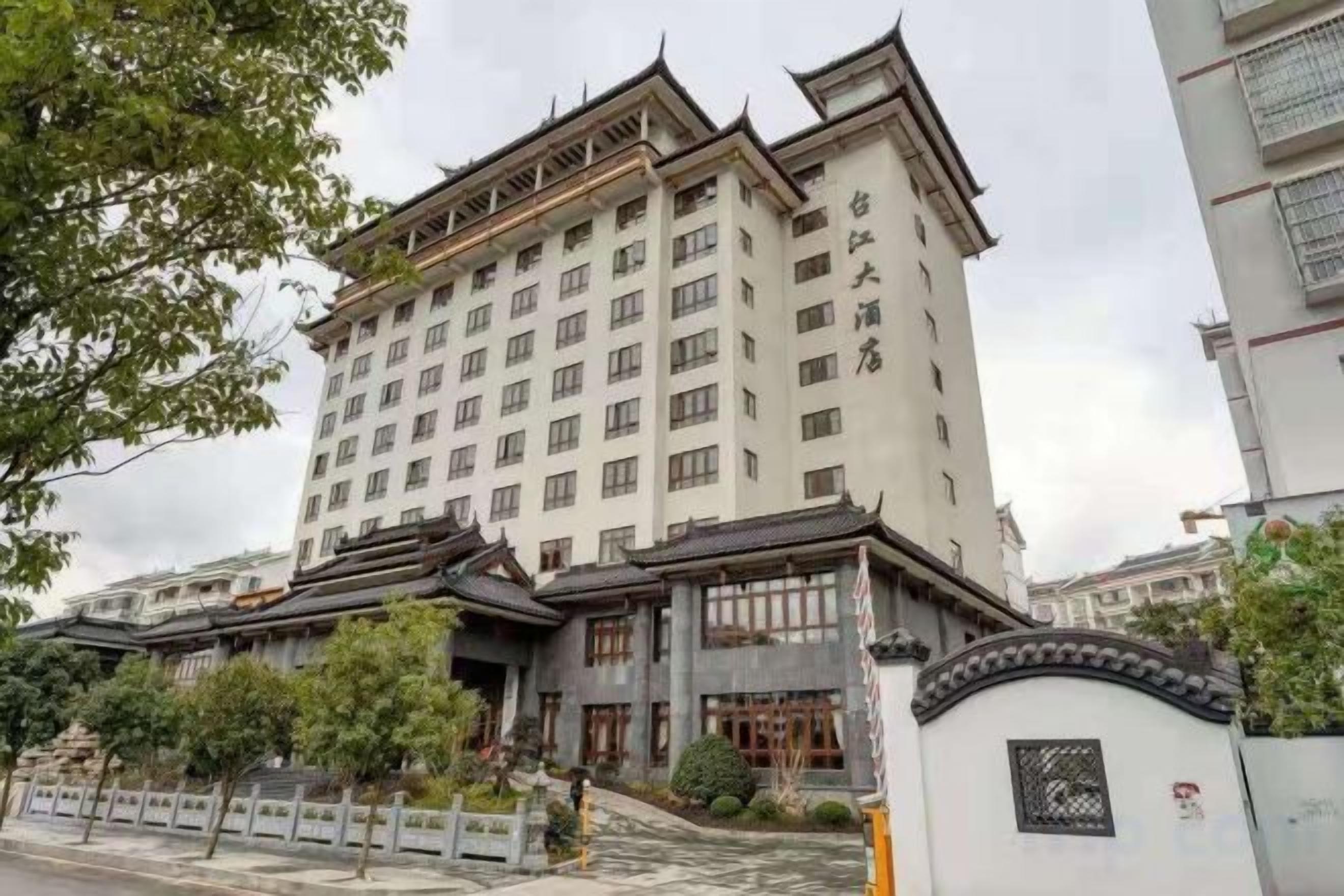 Un hotel de varios pisos con estilo arquitectónico tradicional, que cuenta con una entrada destacada con una reja y una amplia fachada.