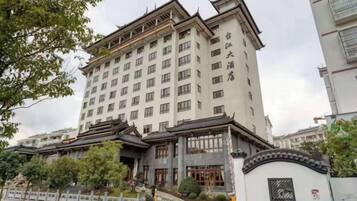 Un hotel de varios pisos con estilo arquitectónico tradicional, que cuenta con una entrada destacada con una reja y una amplia fachada.