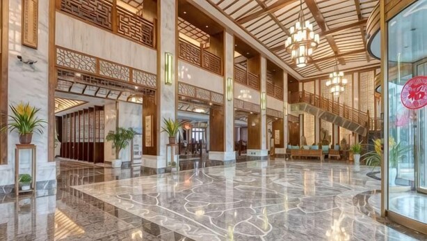 A spacious lobby with a marble floor, wooden columns, and a staircase leading to upper levels. - Taijiang Hotel (Taijiang)