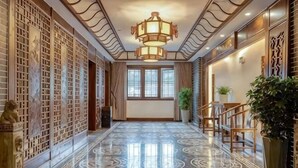 A hallway with a marble floor, a traditional Chinese-style wall, and a modern chandelier. - Taijiang Hotel (Taijiang)