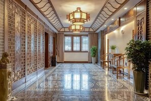 A hallway with a marble floor, a traditional Chinese-style wall, and a modern chandelier. - Taijiang Hotel (Taijiang)