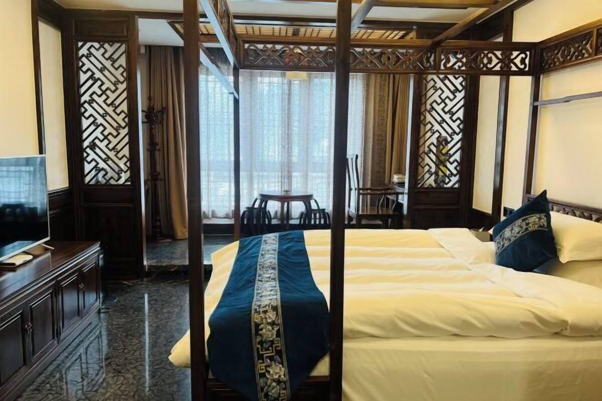 Une chambre d’hôtel avec un grand lit, une télévision, un bureau et une chaise.