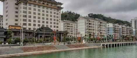A hotel with multiple floors, a waterfront view, and a traditional architectural style.