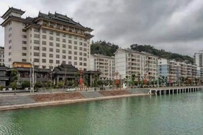 A hotel with multiple floors, a waterfront view, and a traditional architectural style.