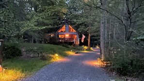 Een chalet met houten gevel, een veranda en een vlag.