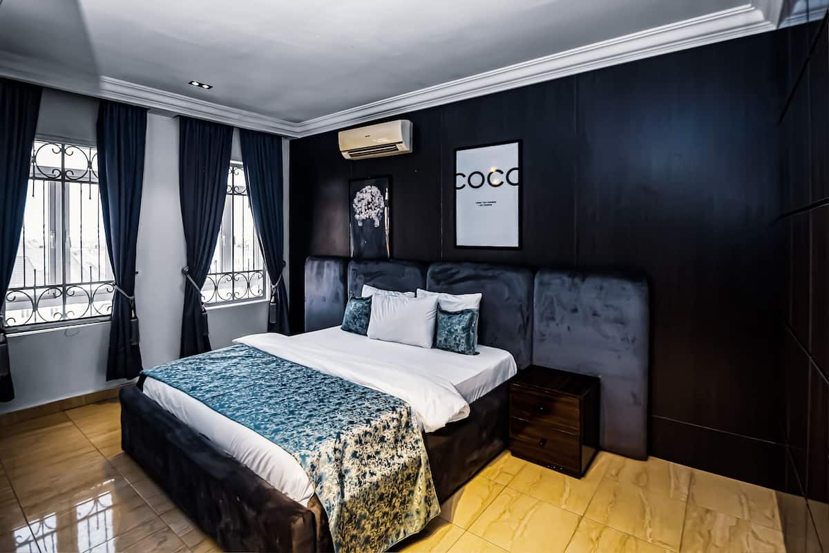 Un dormitorio con cama, mesita de noche y aire acondicionado de pared.