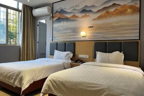 Une chambre d’hôtel avec deux lits, une grande fresque murale et une fenêtre avec des rideaux.