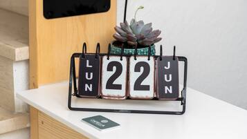 Un calendrier affichant le mois de juin, une petite plante succulente et, à l’arrière-plan, un meuble en bois.