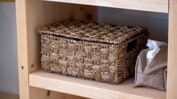 A wicker basket on a wooden shelf.
