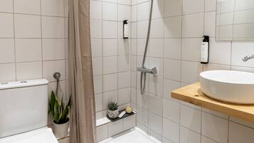 A modern bathroom with a shower, toilet, and sink.