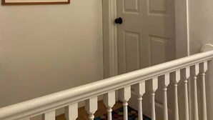 A staircase with white railings leading to a door with a black doorknob.
