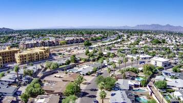 A residential area with multiple buildings, roads, and a large body of water in the distance.
