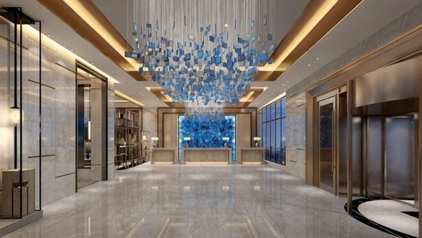 A spacious lobby with a modern chandelier, a reception desk, and a large blue wall feature. - Ya Le Xuan Hotel (Shehong)