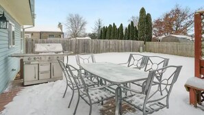 A backyard with a metal table and chairs, a grill, and a wooden fence. - PROMO 10% WEEKLY AND 15% MONTHLY OFF
Naperville/Aurora, King Bed, Fenced Yard! (Aurora)