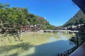 A riverside view with traditional buildings, a bridge, and a clear sky. - Fenghuang Fanyin Zhenpin Inn (Fenghuang County)