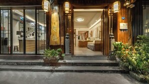 A traditional wooden building with a welcoming entrance, a reception area, and a visible dining space. - Fenghuang Fanyin Zhenpin Inn (Fenghuang County)