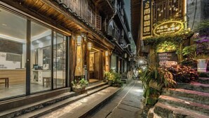 A narrow street with a restaurant on the left and a coffee shop on the right. - Fenghuang Fanyin Zhenpin Inn (Fenghuang County)
