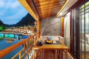 Enjoy breathtaking views of the traditional village from this balcony, complete with a table set for a relaxing moment.