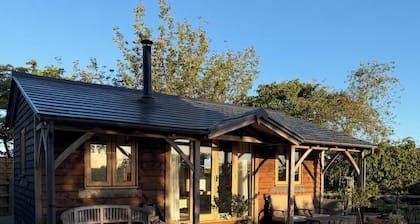 Escape to The Gatehouse Lodge, a bespoke oak retreat on a working farm near Deal. Enjoy distant sea views, a cosy log burner, private secure garden, kitchen, free parking and slow EV charger —perfect for two adults, a child and one well-behaved dog.