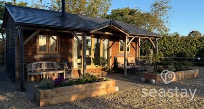 Escape to The Gatehouse Lodge, a bespoke oak retreat on a working farm near Deal. Enjoy distant sea views, a cosy log burner, private secure garden, kitchen, free parking and slow EV charger —perfect for two adults, a child and one well-behaved dog.