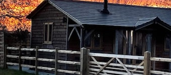 Gatehouse Lodge a bespoke Lodge on working farm with a distant sea view and a secluded garden with fire.